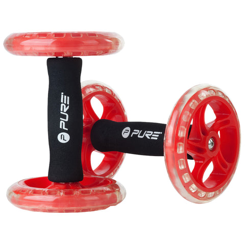 A red ab roller features two large wheels connected by a central handle with grips used for core workouts on flat surfaces to enhance strength and stability.