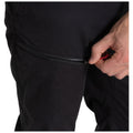 Black pants with a side zip pocket are shown being unzipped by a hand holding the zipper pull in a casual setting likely indoors or outdoors.