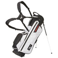 A white golf bag stands upright with an attached shoulder harness and legs extended for support. It features multiple zippered pockets for storage and is ready for use on the golf course.