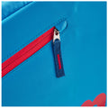 A blue fabric bag features a red zippered pocket highlighted by a silver zipper pull with a blue and red woven tab visible against a smooth backdrop.