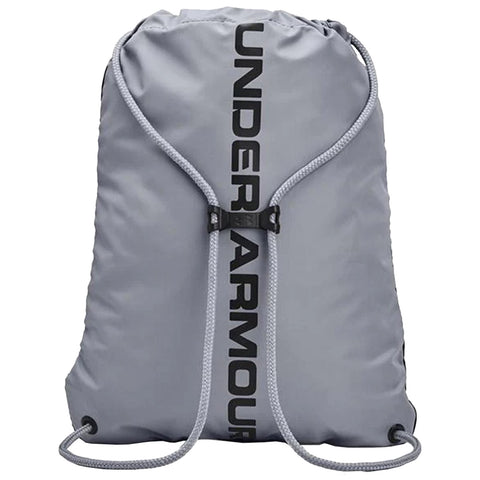 A gray drawstring backpack with a black logo prominently displaying the word UNDERARMOUR is cinched at the top reflecting a sporty design ideal for casual or athletic use.