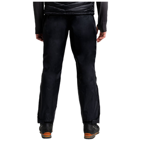 Black outdoor pants are worn by a person standing with their back facing the viewer in a neutral setting showcasing durable fabric and practical design for outdoor activities.