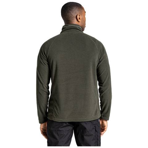 A person is wearing a dark green fleece jacket standing with their back turned in a neutral environment showing the warm and casual nature of the clothing.