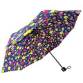 A colorful umbrella features a navy background adorned with various fruit and flower patterns while being opened to provide shade or shelter in a casual outdoor setting