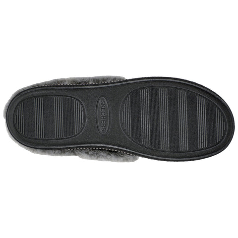 A gray footwear object with a textured rubber sole rests against a plain white background showing grooves designed for traction and an embossed brand name near the center.