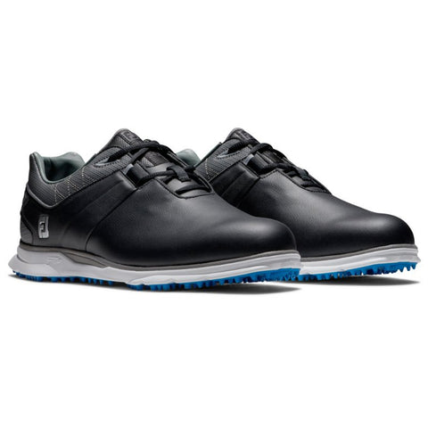 Black golf shoes are displayed standing side by side featuring a smooth leather exterior a grey mesh collar and a blue spiked sole designed for traction on the golf course.