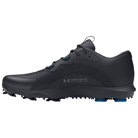 A black athletic shoe features a textured design with blue accents on the sole while positioned against a plain white background highlighting its sleek silhouette and cleated bottom for traction.