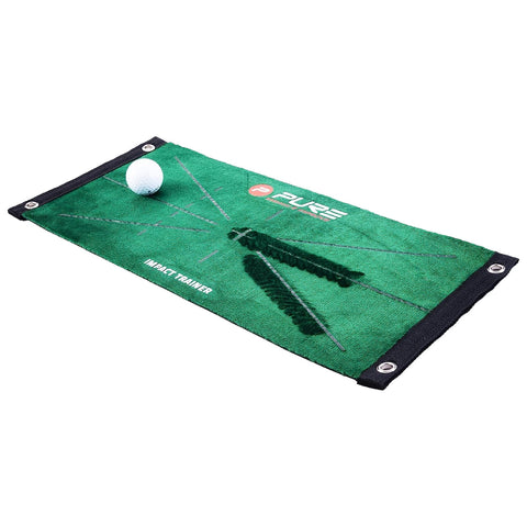 A green golf impact training mat lies flat with a white golf ball positioned on it demonstrating practice purposes surrounded by outlines that guide proper swing mechanics