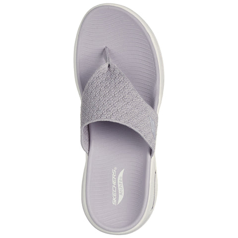 A light gray flip-flop with a textured strap is positioned centrally. It is designed for casual wear and appears set against a plain white background.