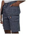 Gray cargo shorts are being worn by a person who has their hand in one of the side pockets showcasing the shorts' utility features and practical design in a casual setting.