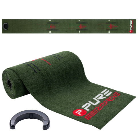 A green putting mat is unrolled on the ground featuring yardage markings and the word "PURE" prominently displayed. A black circular ring for securing the mat is nearby.