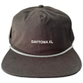 A dark brown cap rests on a flat surface featuring the text DAYTONA XL stitched in contrasting white and an additional white rope detail around the brim.