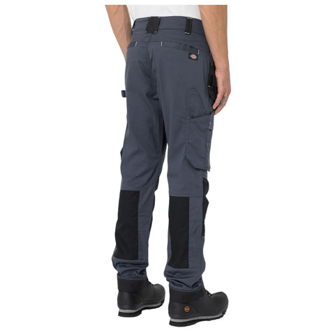 Dark gray cargo pants with contrasting black panels are worn by a person standing upright. The breathable fabric features pockets on the sides, suited for work or outdoor activities.