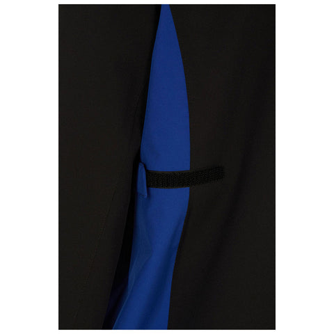 A piece of clothing featuring a combination of black and blue fabric is positioned with a Velcro strap visible on a side seam, suggesting a stylish design in a textile context.