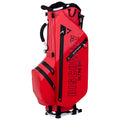 A red golf bag is standing upright showcasing multiple zippered pockets and a handle on top with branded text "DISCOVERY ULTRA DRY" prominently displayed on the side.