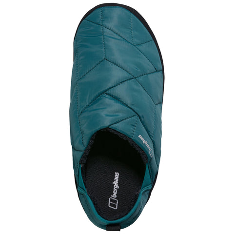 A teal slip-on shoe features a quilted design and an open heel with a black sole. The interior has a textured lining, suggesting comfort and warmth for casual wear.