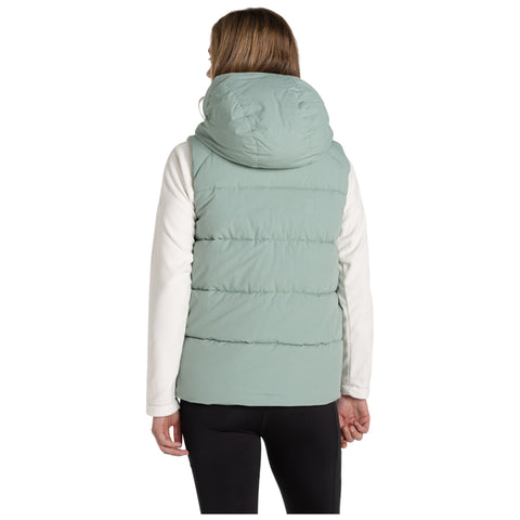 A person wearing a light green puffy vest stands with their back facing the viewer in a neutral background suggesting outdoor wear or casual attire