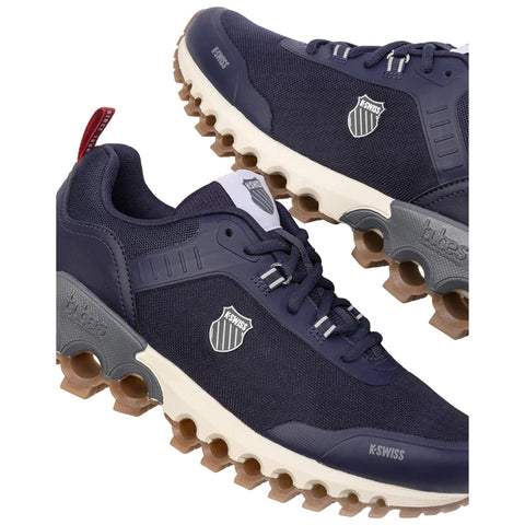 Navy blue athletic shoes with a distinctive sole design are displayed side by side featuring a logo on the tongue and side highlighting their modern design and casual appeal.