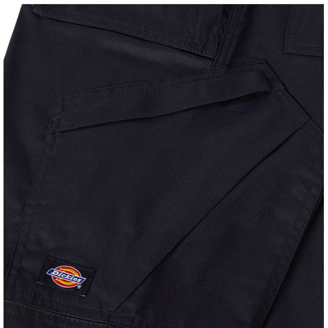 A black fabric garment features multiple pockets and detailing showcasing the Dickies brand logo prominently displayed on an upper patch. The texture appears durable and suited for workwear.