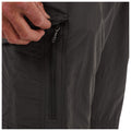 A hand pulls open a zipper from the side of dark-colored shorts, revealing a hidden pocket which suggests functionality in a casual or outdoor context.