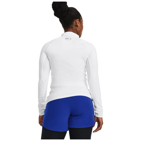 A person is standing with their back to the viewer wearing a white long-sleeve top and blue shorts in a neutral setting, suggesting an active or sporty context.