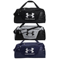 Three sport duffel bags are stacked vertically. Each bag features a prominent Under Armour logo and has different color patterns: black, gray, and navy. They have sturdy handles and adjustable straps.