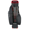 A black golf bag with red accents stands upright featuring multiple club slots on top and external pockets for storage while showing a secure leg lock mechanism at the base.