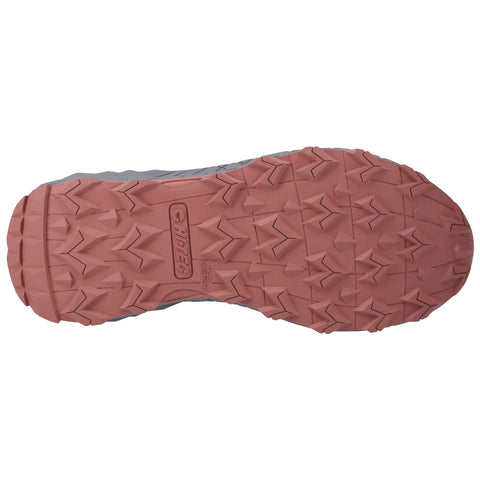 A shoe sole is displayed showcasing a rugged tread pattern designed for traction the sole is primarily grey with a pinkish-red rubber section highlighting its design for outdoor activities or sports.