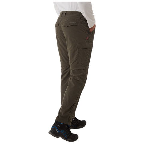 Cargo pants are worn by a person standing with hands in pockets in a neutral background, showcasing their utilitarian design and paired with black shoes featuring blue accents.