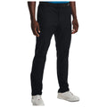 Black golf chinos are worn by a person standing upright, styled with a belt and collared shirt while wearing white athletic shoes in a neutral background. The focus is on the garment’s sleek design and footwear combination.