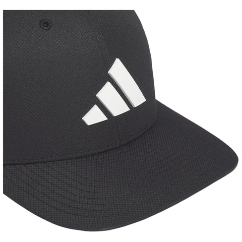 A black cap features a prominent white three-stripe logo on its front left side while resting flat and slightly angled, showcasing a textured fabric surface in a bright setting.