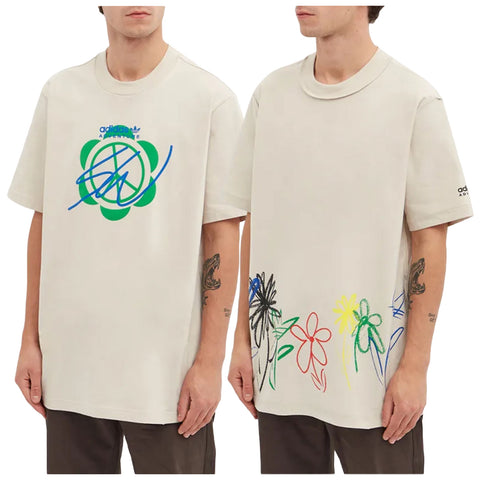 A light beige oversized t-shirt features distinct graphics on the front and back including colorful floral designs and a signature-like logo along with branding on the sleeve worn by a model.