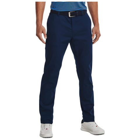 A person stands wearing navy blue golf chinos with a black belt featuring a silver buckle, complemented by a striped blue and white shirt and white sneakers, creating a casual yet polished look in a relaxed setting.A person stands wearing navy blue golf chinos with a black belt featuring a silver buckle, complemented by a striped blue and white shirt and white sneakers, creating a casual yet polished look in a relaxed setting.