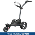 A golf trolley is positioned upright featuring three large, stylish wheels and a raised handle for maneuvering in a golf course environment promoting ease of transport for golf equipment. FREE TRAVEL COVER.