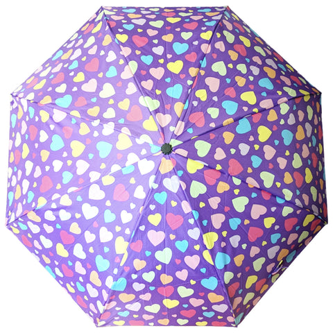 A purple umbrella covered in colorful heart patterns is open and displayed from above in a bright, cheerful manner, suggesting a playful atmosphere suitable for a sunny day.