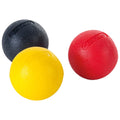 Three textured rubber balls are arranged closely together one black one yellow and one red showcasing vibrant colors and varying surface patterns in a plain light background