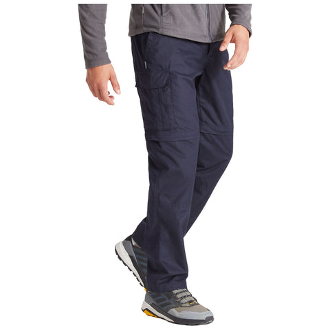 Navy cargo pants are being worn by a person who is walking. The surrounding context is a neutral background that emphasizes the clothing without distractions.