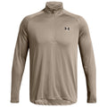 A long-sleeved, light beige athletic shirt features a quarter-zip collar and an Under Armour logo on the left chest, suitable for active wear in various outdoor environments.