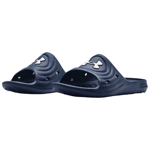 Dark blue slide sandals with open toes feature a prominent white logo on the top and ventilation holes. They are positioned side by side on a plain white background.