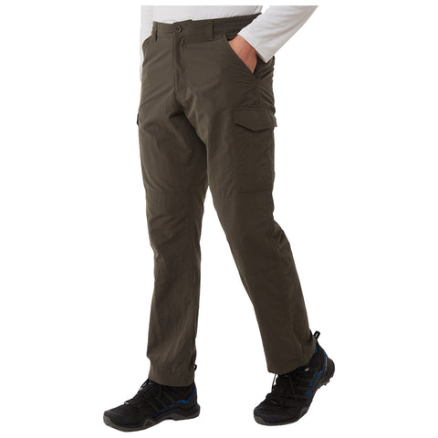 Cargo pants are worn by a person standing with one hand in a pocket showcasing their practical design and utility while wearing black shoes in a neutral background.