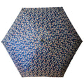 A patterned umbrella with a dark blue background and small floral designs opens wide to provide shade or shelter in a rain or sunny environment.