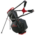 A black and red golf bag stands upright with extended legs featuring multiple zippered compartments and padded straps designed for carrying it comfortably on the back in various outdoor settings.