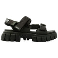 Black sandals with thick soles and adjustable straps are displayed. The design combines sporty and stylish elements suitable for casual wear in various environments.