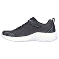 A black athletic shoe with a textured upper and white sole rests on a flat surface showcasing its sleek design and lacing system suitable for casual or fitness activities.