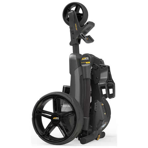 A sleek black and gray golf push cart stands upright in a folded position featuring large wheels and a handle for easy transport in an outdoor or indoor space.