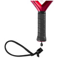 A red-handled paddle with a textured black grip is displayed. It features a lanyard attachment near the bottom, suggesting use in a water sport or activity context.