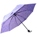 A purple umbrella with a dotted pattern is opened wide showing its canopy in an upright position ready for use during rain or sun protection.