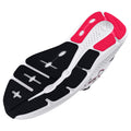 A sneaker sole features black rubber grooves with white sections and pink accents the sole is designed for traction and comfort showcasing modern athletic shoe design in a neutral setting