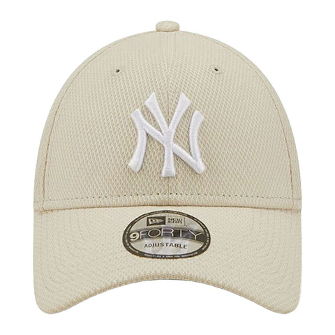 A beige baseball cap features a white embroidered NY logo on the front and has a curved brim with adjustable sizing for the wearer. The cap is made of mesh material.