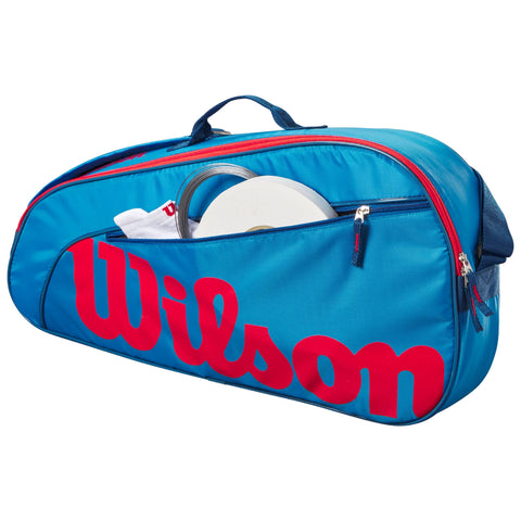 A blue sports bag with a large red "Wilson" logo is partially open revealing a white disc and a white item inside showcasing its use for carrying sports equipment.